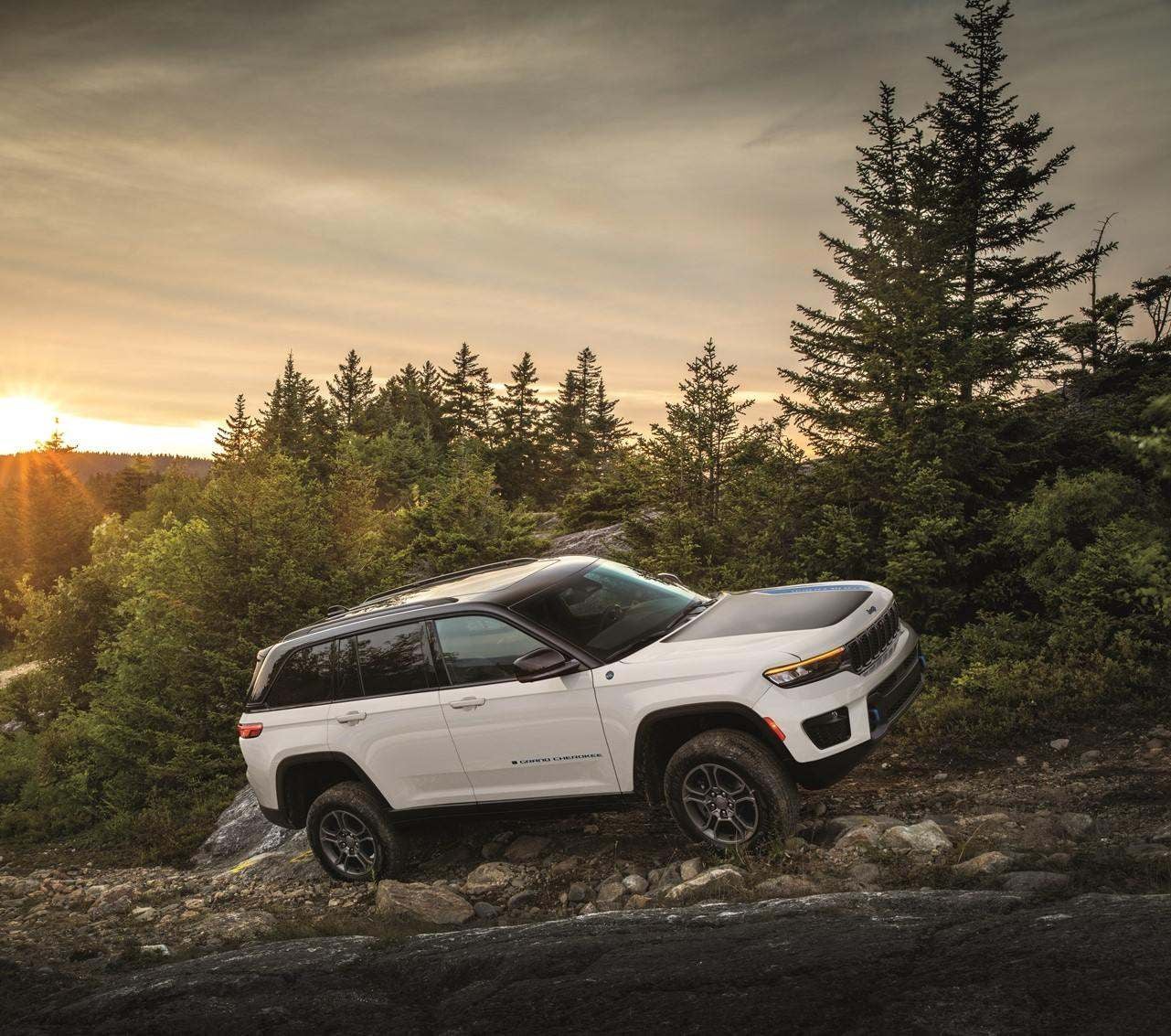 White 2024 Jeep Grand Cherokee traveling up a mountain-like road at sunset